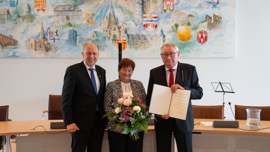 Landrat Christoph Rüther (l.) hat das Verdienstkreuz der Bundesrepublik Deutschland stellvertretend für den Bundespräsidenten an den Haarener Josef Stratmann (r.) verliehen. Ehefrau Anna Stratmann (Mitte) freut sich mit. © Kreis Paderborn